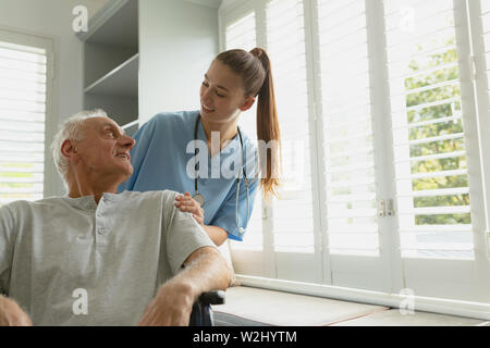 Femme avec active senior man in wheelchair at home Banque D'Images