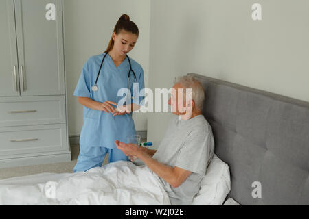 Femme médecin d'administrer un médicament à actif senior patient dans la chambre Banque D'Images