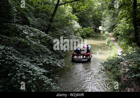 Un bateau est conduite le long du canal près de Basingstoke à Dogmersfield dans le Hampshire. Banque D'Images