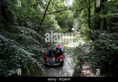 Un bateau est conduite le long du canal près de Basingstoke à Dogmersfield dans le Hampshire. Banque D'Images