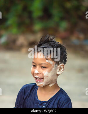 Asian boy jouer l'eau et la farine dans Songkran festival ou nouvel an Thaï en Thaïlande. Banque D'Images