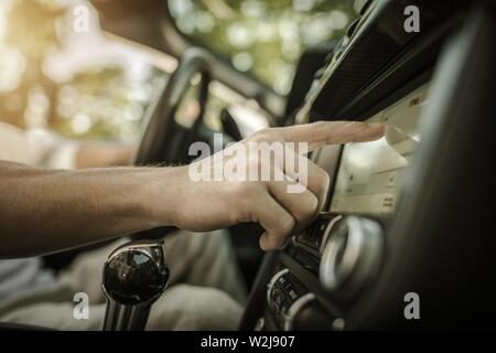 Radio écoute la musique dans une voiture. Changement des stations à la recherche du bon son. Véhicule décapotable Road Trip in Style. Système Audio et multimédia. Banque D'Images