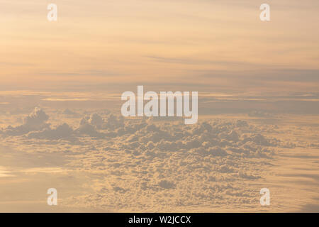 Voler au-dessus des nuages au crépuscule du temps. Banque D'Images