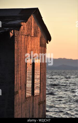 Vieux bateau maison sur quai à Clear Lake en Californie qui est en train de s'effondrer au coucher du soleil aux Etats-Unis - Plus grand lac naturel d'eau douce en Californie du Nord Banque D'Images