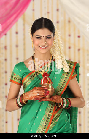 Woman holding a kalash and smiling Stock Photo