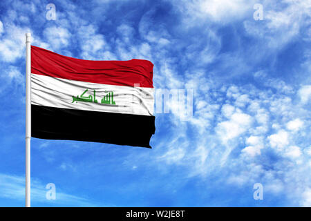 Drapeau national de l'Irak sur un poteau en face de ciel bleu Banque D'Images