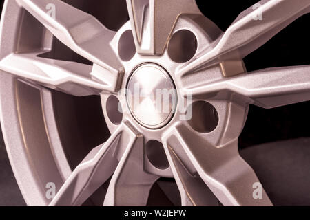 Beau disque en fonte d'argent pour une voiture sur un fond noir. close up Banque D'Images