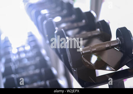 Ensemble d'haltères courtes noir. Close up de nombreux metal haltères courtes sur une grille dans le sport centre de remise en forme , l'équipement de formation de poids concept. Banque D'Images