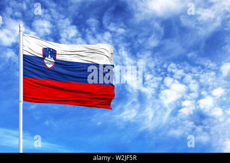 Drapeau national de la Slovénie sur un poteau en face de ciel bleu Banque D'Images