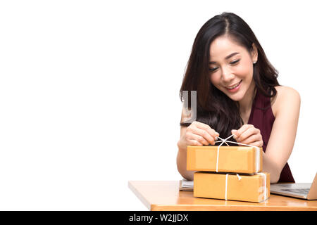 Les femmes asiatiques colis emballage sur la table et fond blanc, femme recevoir boîte en carton à partir de l'achat en ligne de commande, Expédition et livraison achats et b Banque D'Images