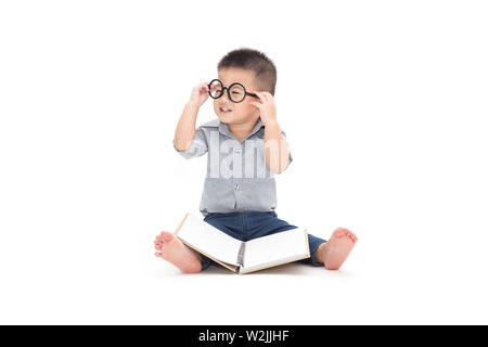 Mignon petit enfant jouer avec réserve et porter des lunettes alors qu'il était assis sur le plancher isolé sur fond blanc, Asian baby boy et de l'éducation concept Banque D'Images