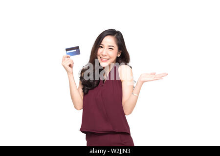 Young smiling beautiful Asian woman presenting carte de crédit en main pour effectuer le paiement shopping isolé sur fond blanc Banque D'Images