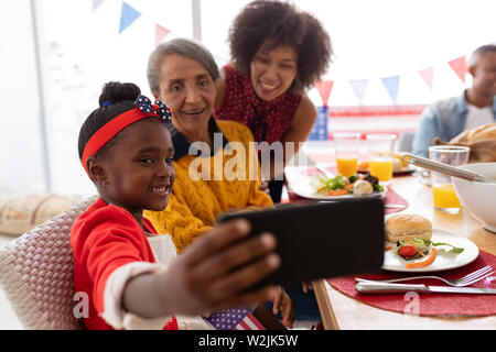 Multi-generation family en tenant avec selfies ayant repas sur une table à manger Banque D'Images