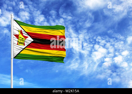 Drapeau national du Zimbabwe sur un poteau en face de ciel bleu Banque D'Images