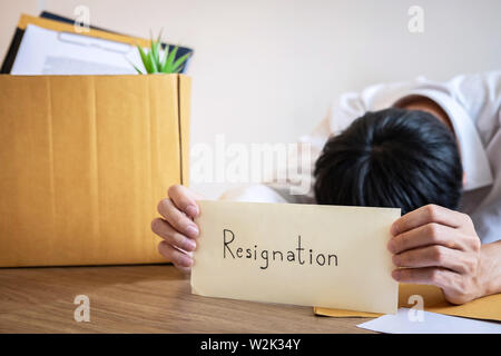 Stressed businessman va être démission et effets personnels d'emballage société et fichiers dans boîte en carton brun, changeant et démissionnera de travail conceptuel Banque D'Images