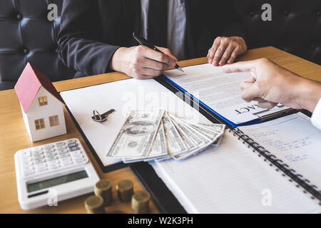 Agent immobilier Courtier présentant et attendre au client après la signature du contrat avec l'accord immobilier demande approuvée, l'achat ou sur mo Banque D'Images