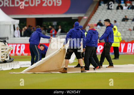 Old Trafford, Manchester, Royaume-Uni. 9 juillet 2019. ICC Cricket World Cup demi-finale, l'Inde et la Nouvelle-Zélande ; le personnel au sol commencent à retirer le terrain couvrant pour une inspection par les arbitres après le Rain Delay : Action Crédit Plus Sport Images/Alamy Live News Banque D'Images