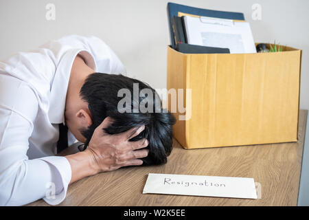 Stressed businessman va être démission et effets personnels d'emballage société et fichiers dans boîte en carton brun, changeant et démissionnera de travail conceptuel Banque D'Images
