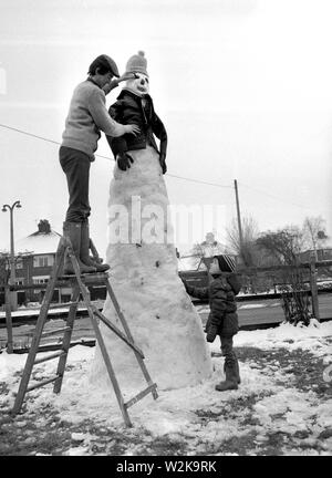 Le père et le fils la construction d'un bonhomme de neige géant dans Yorkshire du Nord 1985 Banque D'Images