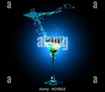 Cocktail coloré dans le verre avec des touches et de citron sur fond sombre. Club partie de divertissement. Lumière Mixte Banque D'Images