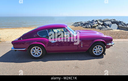 Violet Classic Triumph GT6 garée sur promenade du front de mer. Banque D'Images