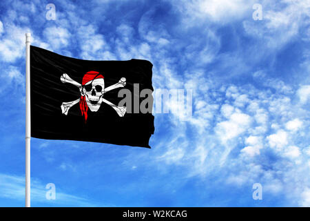 Drapeau de pirate sur un poteau en face de ciel bleu Banque D'Images