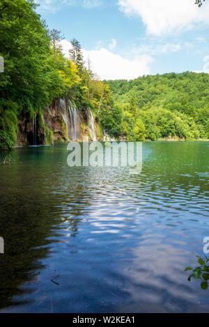 Cascades d'eau douce pure se précipiter brown, roches moussues dans un lac de couleur bleu azur au parc national des Lacs de Plitvice, Plitvice, Croatie Banque D'Images