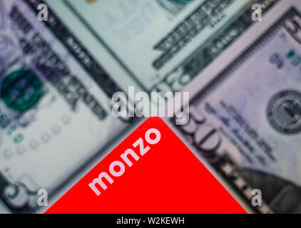 Cartes bancaires Monzo sur un arrière-plan flou de billets de différentes dénominations. Banque D'Images