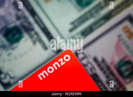 Cartes bancaires Monzo sur un arrière-plan flou de billets de différentes dénominations. Banque D'Images