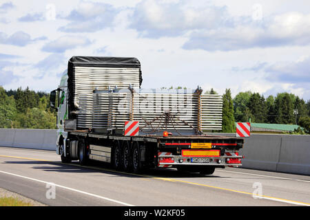 Salo, Finlande. Le 29 juin 2019. MAN TGX 18.500 chariot de Sachs Trans transporte le matériel industriel sur la remorque en charge surdimensionnée, le long de l'autoroute, vue arrière. Banque D'Images