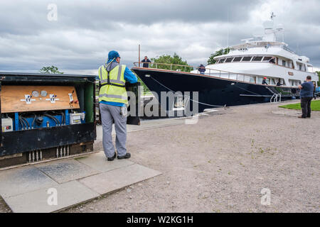 "Lady Rose' passant par Muirtown serrures, Canal Calédonien, Inverness. Lock Keeper à verrouiller la porte de contrôle. Banque D'Images