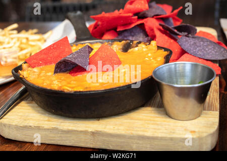 Poulet mexicain Chili faite avec du maïs et des haricots dans un poêlon en fonte, avec le rouge et le bleu des croustilles tortillas et piments jalapenos Banque D'Images