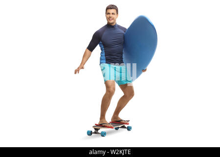 Portrait d'un jeune homme portant un surf et équitation un skateboard isolé sur fond blanc Banque D'Images