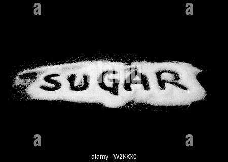 'Word' de sucre cristallisé blanc et du sucre en poudre sur la pierre sombre arrière-plan, Vue de dessus Banque D'Images