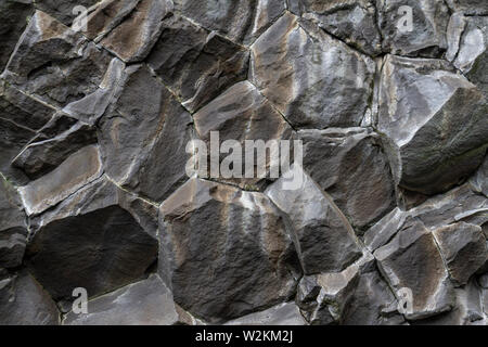 Vue rapprochée de colonnes de basalte hexagonal sur plage de sable noir Reynisfjara qui jouit, dans le sud de l'Islande. Banque D'Images