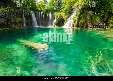 L'eau douce pure se précipiter dans un lac de couleur bleu azur au parc national des Lacs de Plitvice, Plitvice, Croatie Banque D'Images