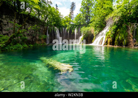 L'eau douce pure se précipiter dans un lac de couleur bleu azur au parc national des Lacs de Plitvice, Plitvice, Croatie Banque D'Images