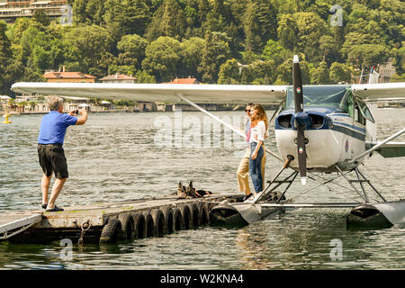 Côme, Lac de Côme, Italie - Juin 2019 : deux personnes ayant leur photo prise avant un voyage en hydravion à partir de Côme, sur le lac de Côme Banque D'Images