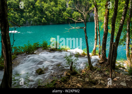 Cascades de l'eau se précipiter en bas de la pente de montagne dans l'eau cristalline du lac de couleur et d'azur à l'Milanovac Le parc national des Lacs de Plitvice, Croatie Banque D'Images