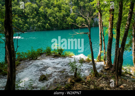 Cascades de l'eau se précipiter en bas de la pente de montagne dans l'eau cristalline du lac de couleur et d'azur à l'Milanovac Le parc national des Lacs de Plitvice, Croatie Banque D'Images