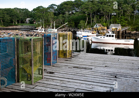 Bateaux de pêche du homard à un quai haute empilée avec des casiers à homard à New Harbor, Maine. Le petit port pittoresque de pocket est un des derniers ports de travail sur le long de la péninsule Pemaquid midcoast Banque D'Images