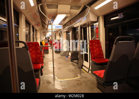 Intérieur de tramway moderne vide avec sièges rouges.Nuit Banque D'Images