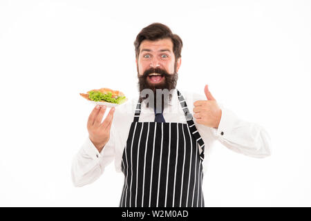 La malbouffe. De délicieux croissants. Homme garçon barbu tablier porter porter la plaque avec de la nourriture. Cafe concept. Guy servant un croissant fourré avec de la laitue et les légumes frais. Alimentation saine. Les Calories et les régimes amaigrissants. Banque D'Images