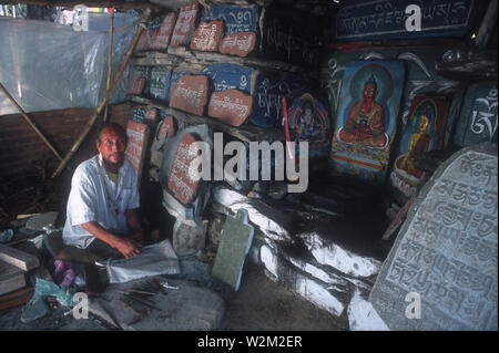 Un sculpteur sur pierre, dans un monastère, dans le Sikkim. Il sculpte les prières et les sculptures de Budhdha colorée à la main dans la pierre. Le Sikkim, Inde. L'année 2000. Banque D'Images