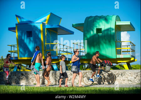 MIAMI - 3 septembre 2018 : Les gens passent le long de la promenade de Miami Beach en face de sauveteur nouvellement construit aux couleurs vives des tours. Banque D'Images