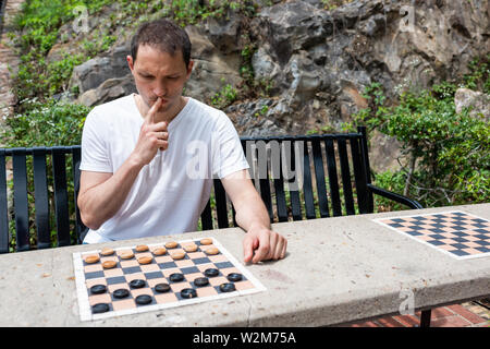 Tableau dames dans un parc à Hot Springs, Arkansas avec la pensée de l'homme jouant au cours de journée d'été assis sur un banc Banque D'Images