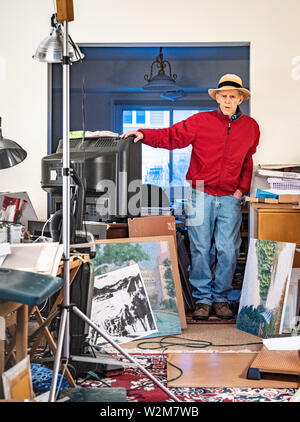 Un artiste est dans son home studio , où il peint des paysages de Banque D'Images