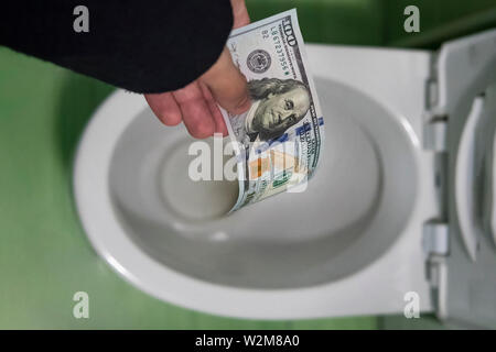 Concept de gaspillage absurde d'argent, de perte, de gaspillage inutile, grand prix de l'eau de rinçage, une centaine de dollars dans les toilettes, la perte d'argent, perdre de l'argent Banque D'Images