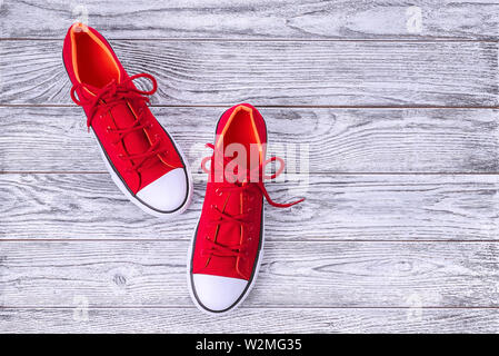 Nouvelles chaussures rouges sur fond de bois avec l'exemplaire de l'espace. Banque D'Images