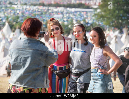 Festival-goers​ posent pour une photo au-dessus du village de tipis à Glastonbury 2019 Banque D'Images